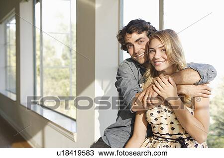 Stock Image - Portrait of young couple at home. Fotosearch
