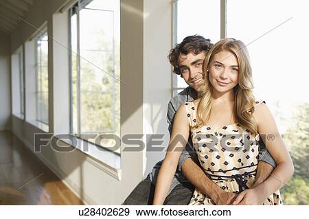 Stock Photo - Portrait of young couple at home. Fotosearch