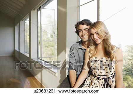 Stock Image - Portrait of young couple in empty home. Fotosearch