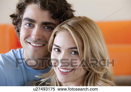 Stock Photography - Portrait of young couple in room. Fotosearch