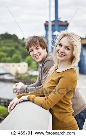 Stock Image - Portrait of young couple on bridge. Fotosearch