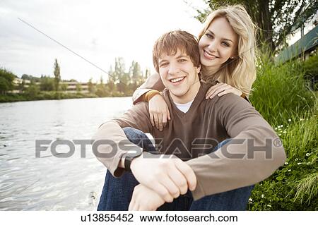 Stock Image - Portrait of young couple on riverbank. Fotosearch