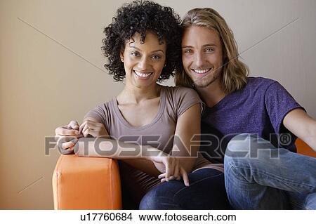 Picture - Portrait of young couple sitting in armchair. Fotosearch