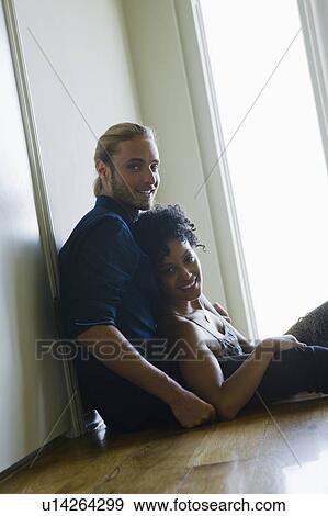 Portrait of young couple sitting on floor View Large Photo Image Stock Photo - Portrait of young couple sitting on floor. Fotosearch
