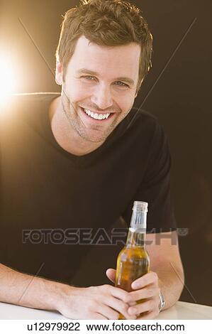 Portrait of young man drinking beer View Large Photo Image Stock Image - Portrait of young man drinking beer. Fotosearch