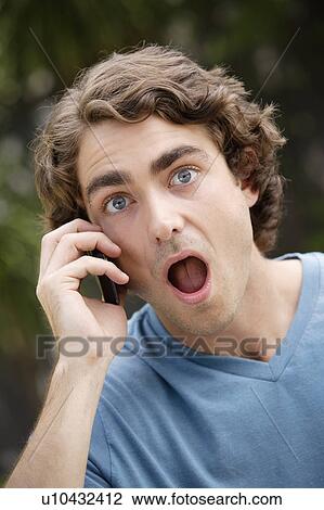 Portrait of young man talking on phone, with facial expression View Large Photo Image Stock Image - Portrait of young man talking on phone, with facial expression. Fotosearch