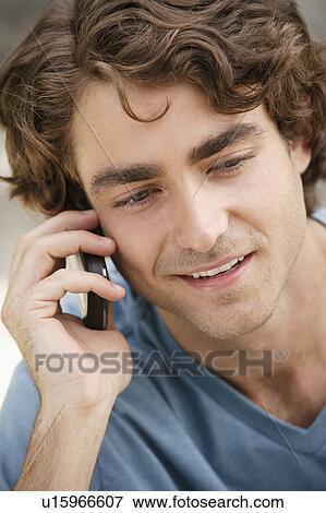 Portrait of young man talking on phone View Large Photo Image Stock Photo - Portrait of young man talking on phone. Fotosearch