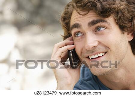 Portrait of young man talking on phone View Large Photo Image Stock Photo - Portrait of young man talking on phone. Fotosearch