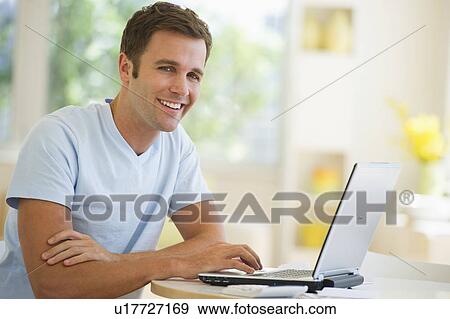 Stock Photo - Portrait of young man using laptop. Fotosearch
