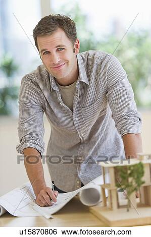 Stock Photograph - Portrait of young man with blueprints. Fotosearch