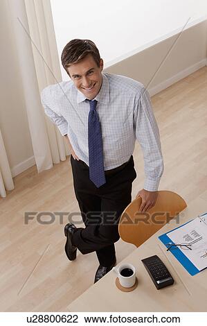 Portrait of young smiling businessman in office View Large Photo Image Stock Image - Portrait of young smiling businessman in office. Fotosearch