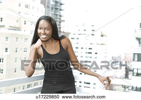 Stock Image - Portrait of young woman on balcony. Fotosearch