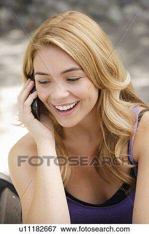 Stock Photo - Portrait of young woman talking on phone. Fotosearch