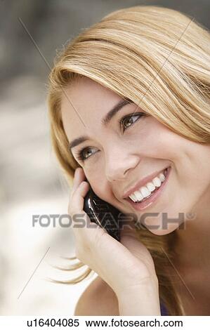 Stock Photography - Portrait of young woman talking on phone. Fotosearch