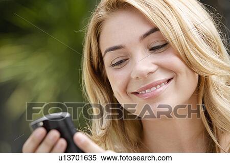 Portrait of young woman text-messaging View Large Photo Image Stock Photography - Portrait of young woman text-messaging. Fotosearch