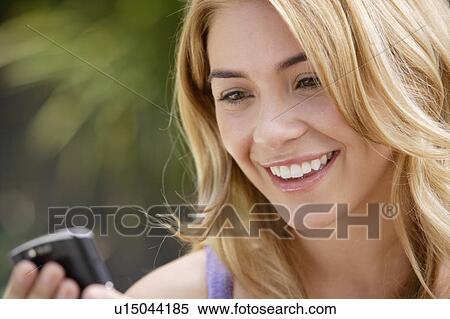 Portrait of young woman text-messaging View Large Photo Image Stock Photography - Portrait of young woman text-messaging. Fotosearch