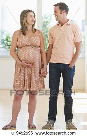 Stock Photograph - Pregnant woman holding partner's hand. Fotosearch