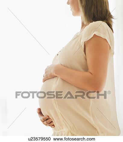 Pregnant woman looking through window View Large Photo Image Stock Image - Pregnant woman looking through window. Fotosearch
