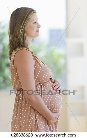 Pregnant woman looking through window View Large Photo Image Stock Photo - Pregnant woman looking through window. Fotosearch