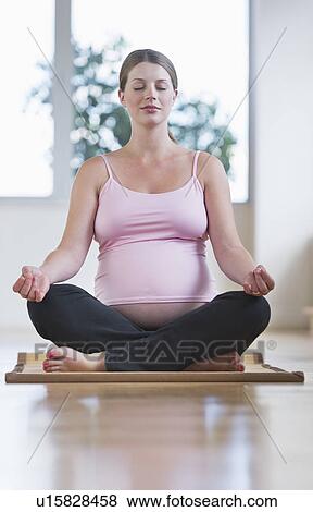 Pregnant woman sitting in lotus position View Large Photo Image Stock Photo - Pregnant woman sitting in lotus position. Fotosearch