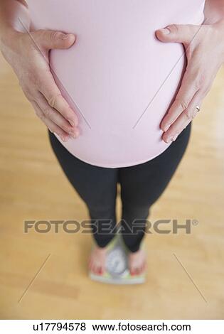 Pregnant woman weighing herself View Large Photo Image Stock Photo - Pregnant woman weighing herself. Fotosearch