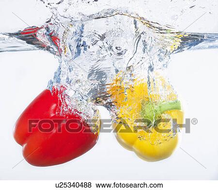 Red and yellow peppers splashing into water, studio shot View Large Photo Image Stock Photo - Red and yellow peppers splashing into water, studio shot. Fotosearch