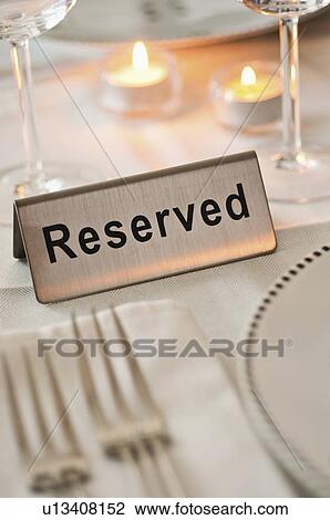 Stock Image - Reservation tag on dining table. Fotosearch