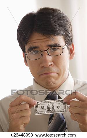 Sad business man holding one dollar note View Large Photo Image Stock Image - Sad business man holding one dollar note. Fotosearch