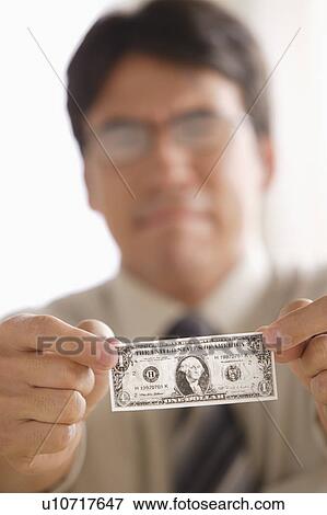 Sad business man holding one dollar note View Large Photo Image Stock Photo - Sad business man holding one dollar note. Fotosearch