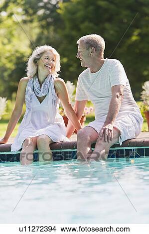 Senior couple at edge of swimming pool View Large Photo Image Picture - Senior couple at edge of swimming pool. Fotosearch