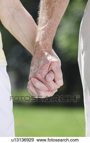 Senior couple holding hands, close-up View Large Photo Image Stock Photo - Senior couple holding hands, close-up. Fotosearch