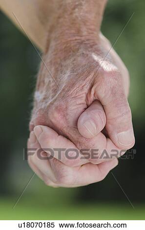 Stock Photography - Senior couple holding hands, close-up. Fotosearch