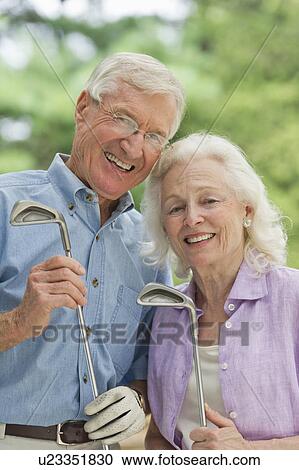Stock Image - Senior couple playing golf. Fotosearch