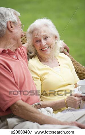 Stock Photo - Senior couple relaxing on outdoor sofa. Fotosearch