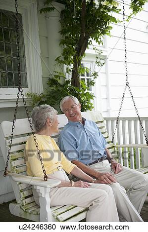Senior couple sitting on porch swing View Large Photo Image Stock Image - Senior couple sitting on porch swing. Fotosearch
