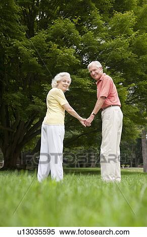 Senior couple standing in park View Large Photo Image Stock Photography - Senior couple standing in park. Fotosearch