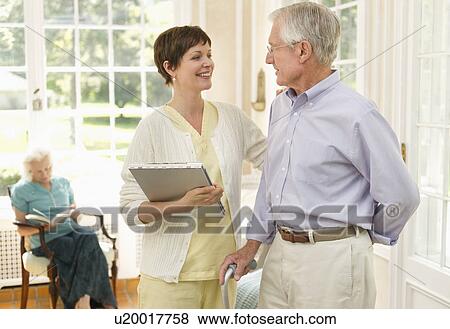 Senior man and nurse talking in nursing home View Large Photo Image Stock Photo - Senior man and nurse talking in nursing home. Fotosearch
