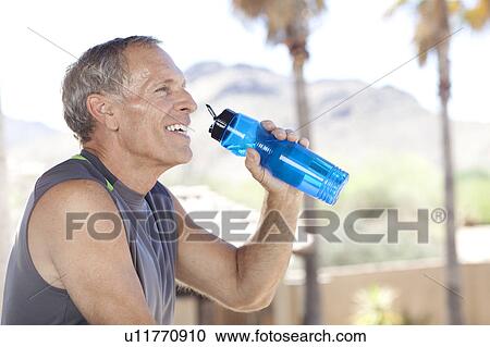 Senior man drinking water from bottle View Large Photo Image Stock Image - Senior man drinking water from bottle. Fotosearch