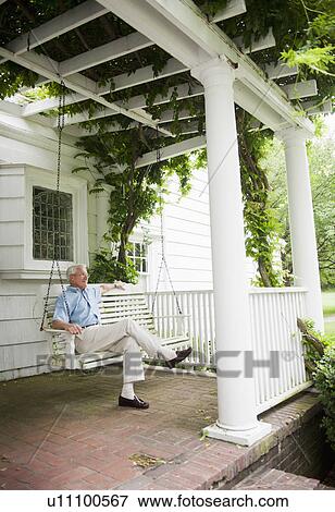Senior man sitting on porch swing View Large Photo Image Stock Photo - Senior man sitting on porch swing. Fotosearch
