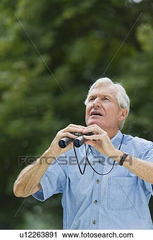 Senior man with binoculars View Large Photo Image Stock Image - Senior man with binoculars. Fotosearch