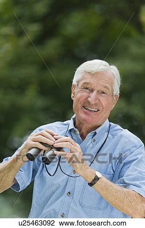 Senior man with binoculars View Large Photo Image Stock Image - Senior man with binoculars. Fotosearch