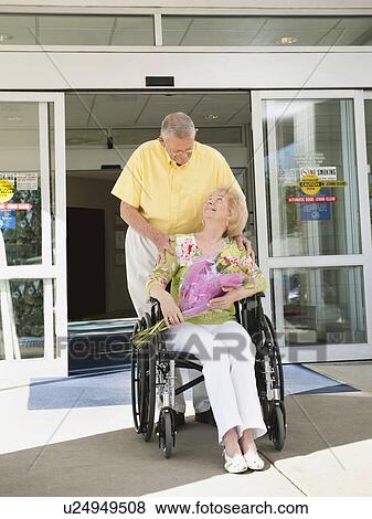Senior people going out from hospital View Large Photo Image Stock Photo - Senior people going out from hospital. Fotosearch