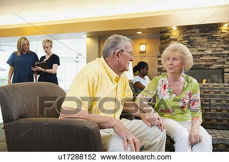 Stock Image - Senior people holding hands in hospital. Fotosearch
