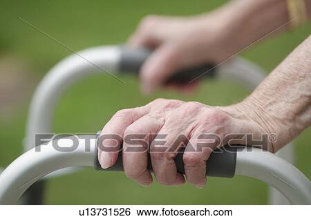 Stock Photograph - Senior walking with walker, close-up of hands. Fotosearch