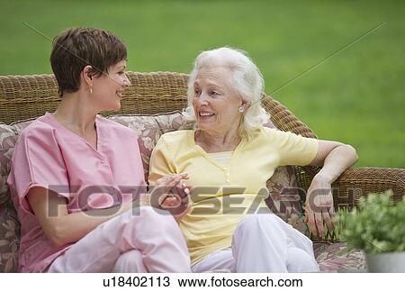 Senior woman and nursing assistant relaxing on outdoor sofa View Large Photo Image Stock Image - Senior woman and nursing assistant relaxing on outdoor sofa. Fotosearch