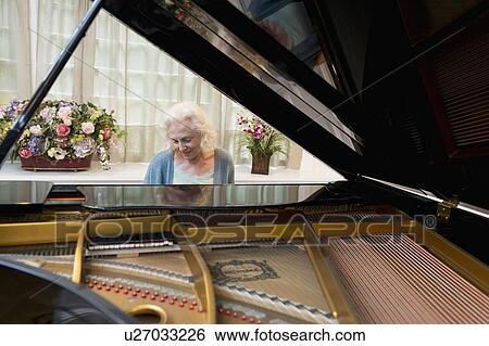 Stock Photograph - Senior woman playing piano. Fotosearch