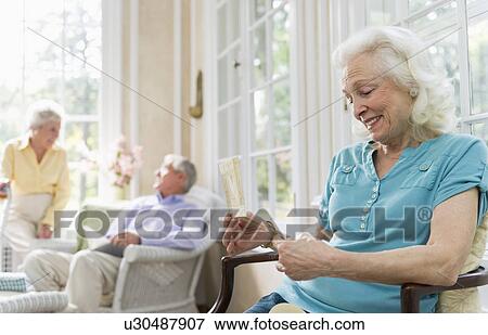 Stock Photo - Senior woman reading greeting card. Fotosearch
