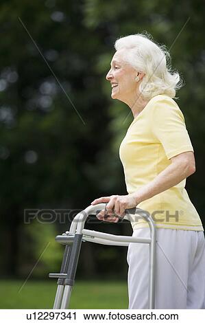 Senior woman walking with walker View Large Photo Image Stock Image - Senior woman walking with walker. Fotosearch