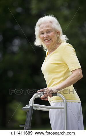 Senior woman walking with walker View Large Photo Image Stock Photo - Senior woman walking with walker. Fotosearch