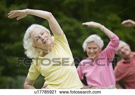 Seniors stretching in park View Large Photo Image Stock Image - Seniors stretching in park. Fotosearch